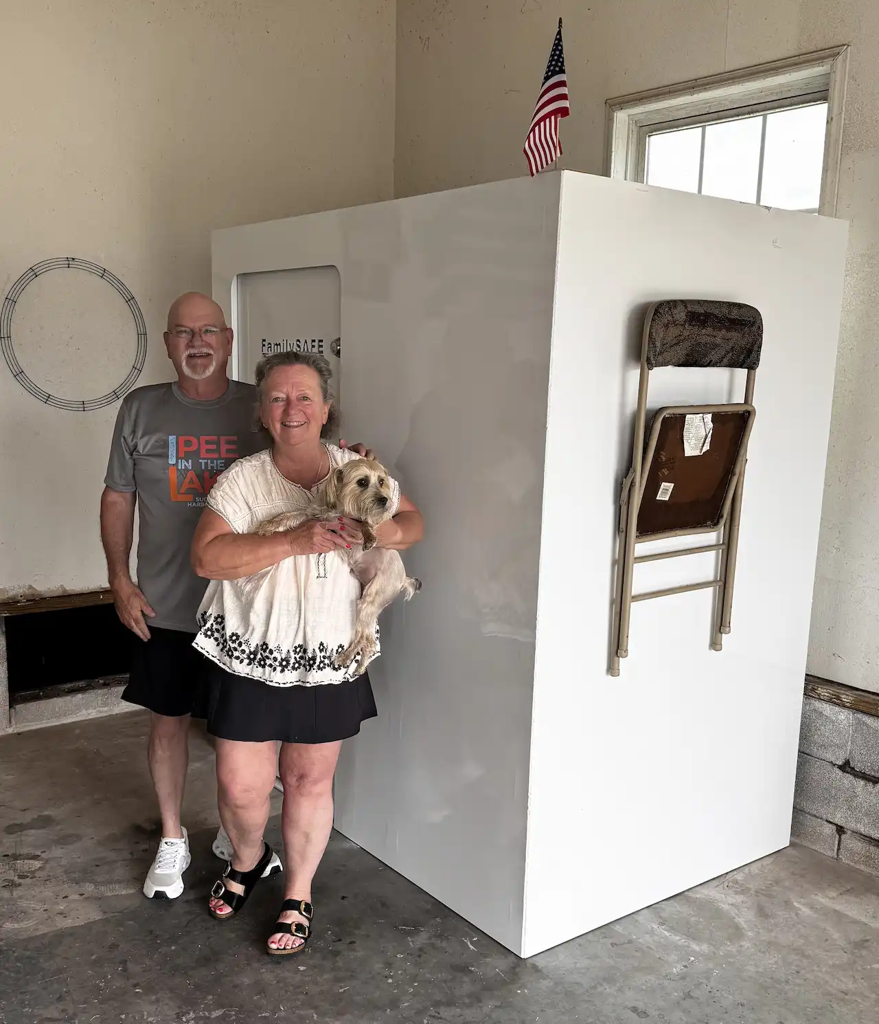 Couple with dog beside indoor storm shelter