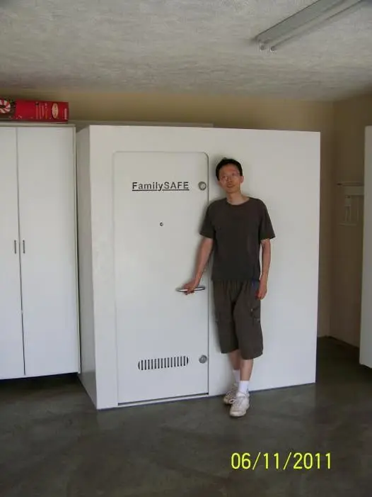 Man standing beside large FamilySAFE vault door