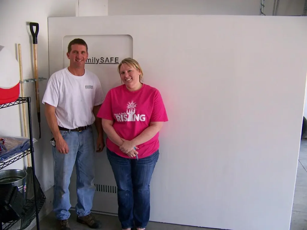 Couple standing beside large white safe door