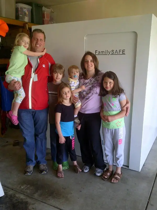 Family standing in front of large white safe