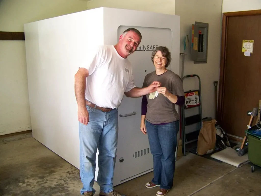 Couple standing beside large white home safe