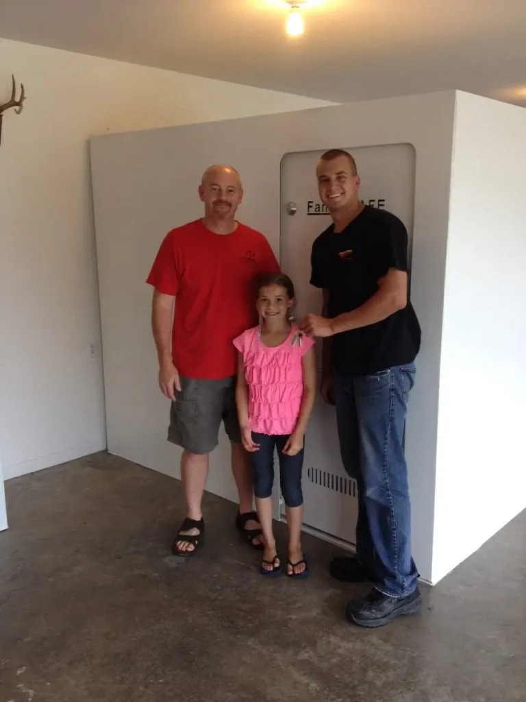 Two men and girl holding keys indoors