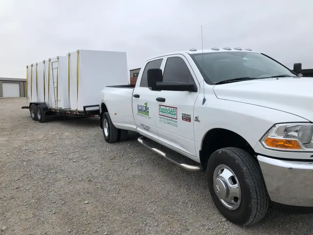 White pickup towing trailer with large white crates