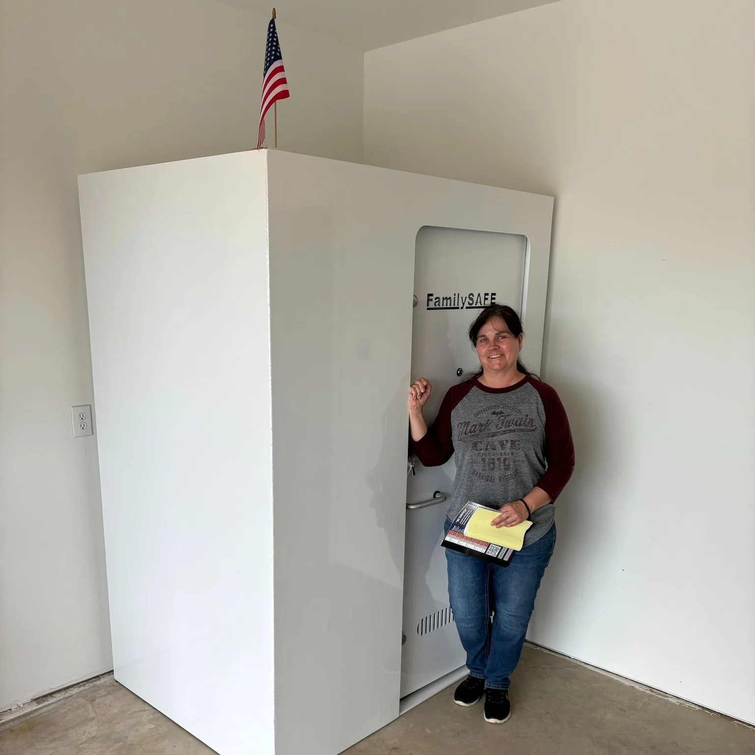 Woman beside storm shelter with American flag