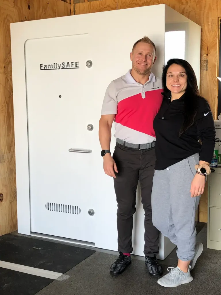 Couple standing beside large FamilySAFE vault door