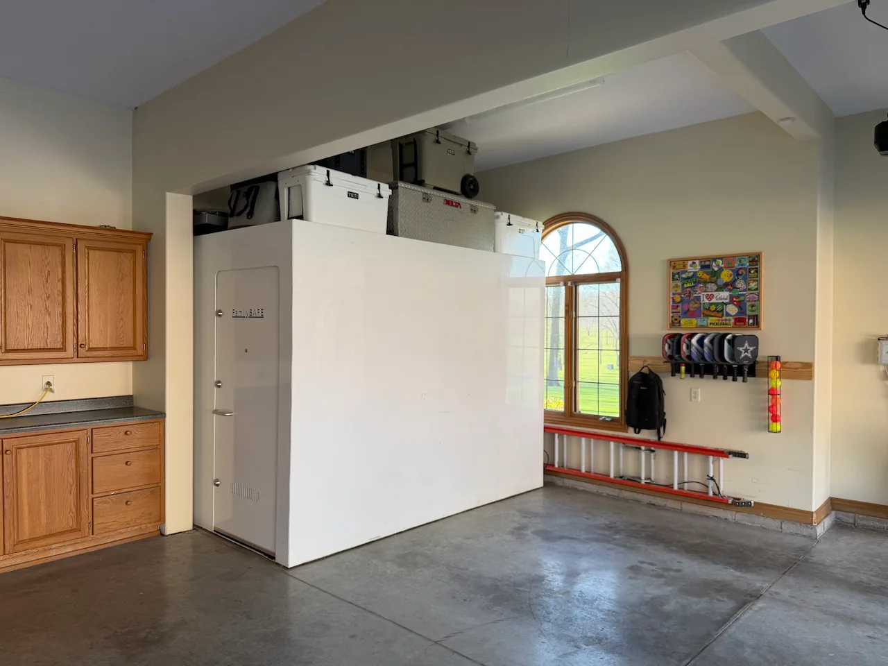 Garage interior with large white storm shelter