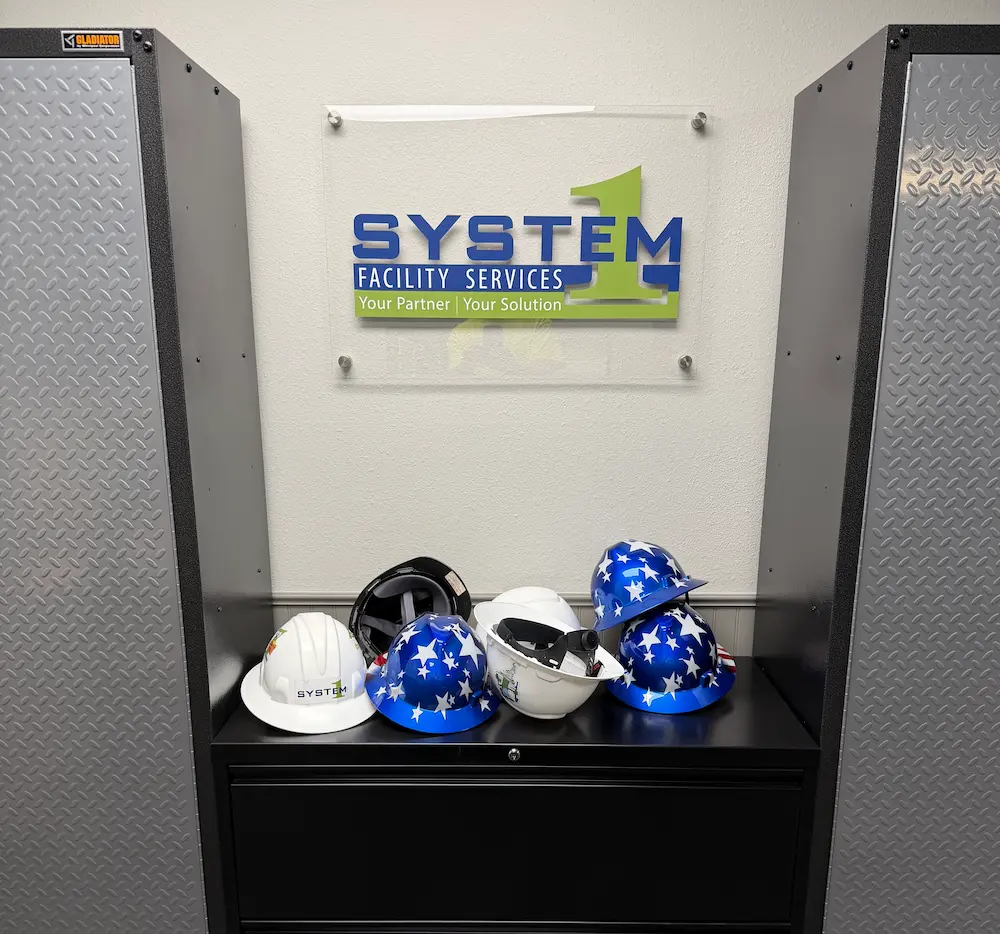 Hard hats beneath System 1 Facility Services sign