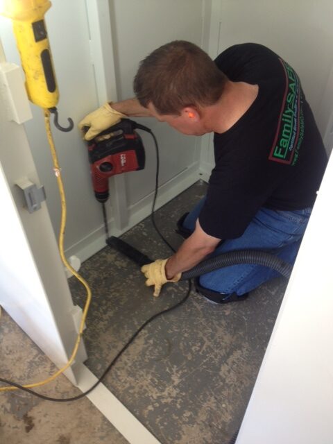Man drilling into floor with power tool