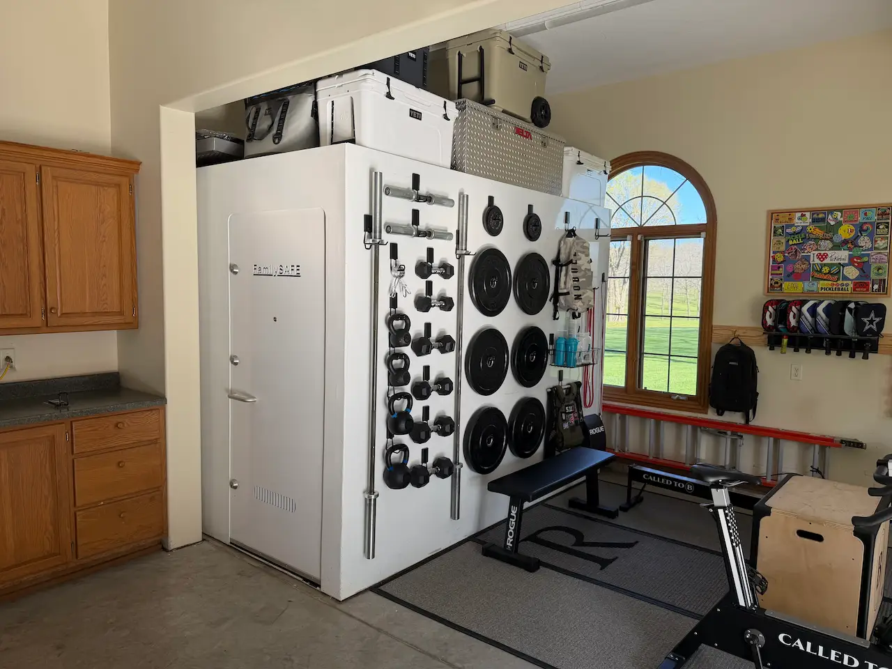 Garage gym with wall-mounted weights and vault door