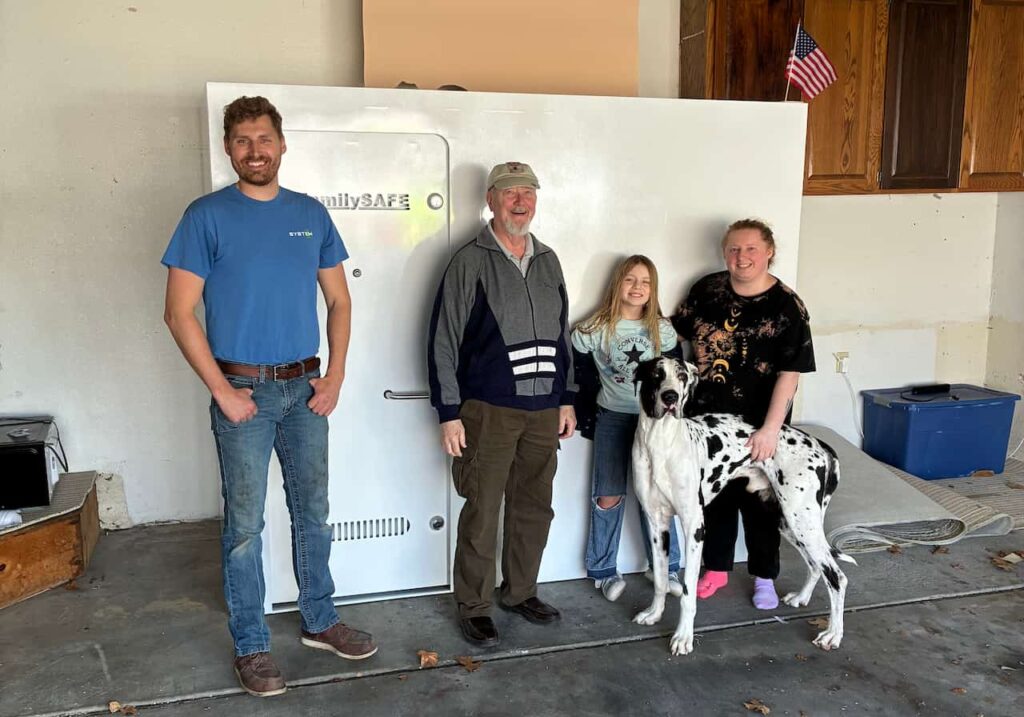 Family posing with large safe and Great Dane