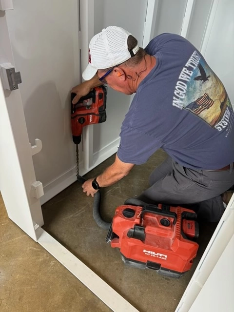 Man drilling into floor with power tool