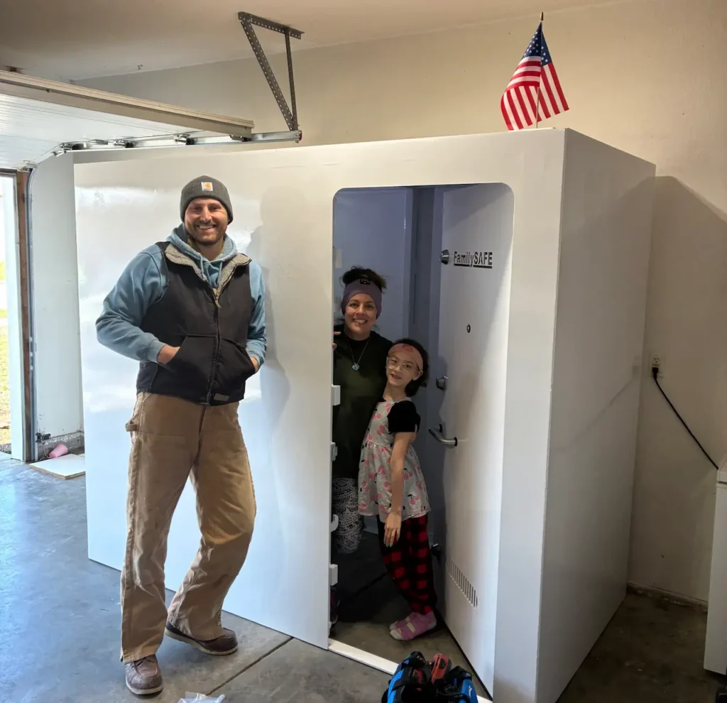 Man stands by family in garage storm shelter