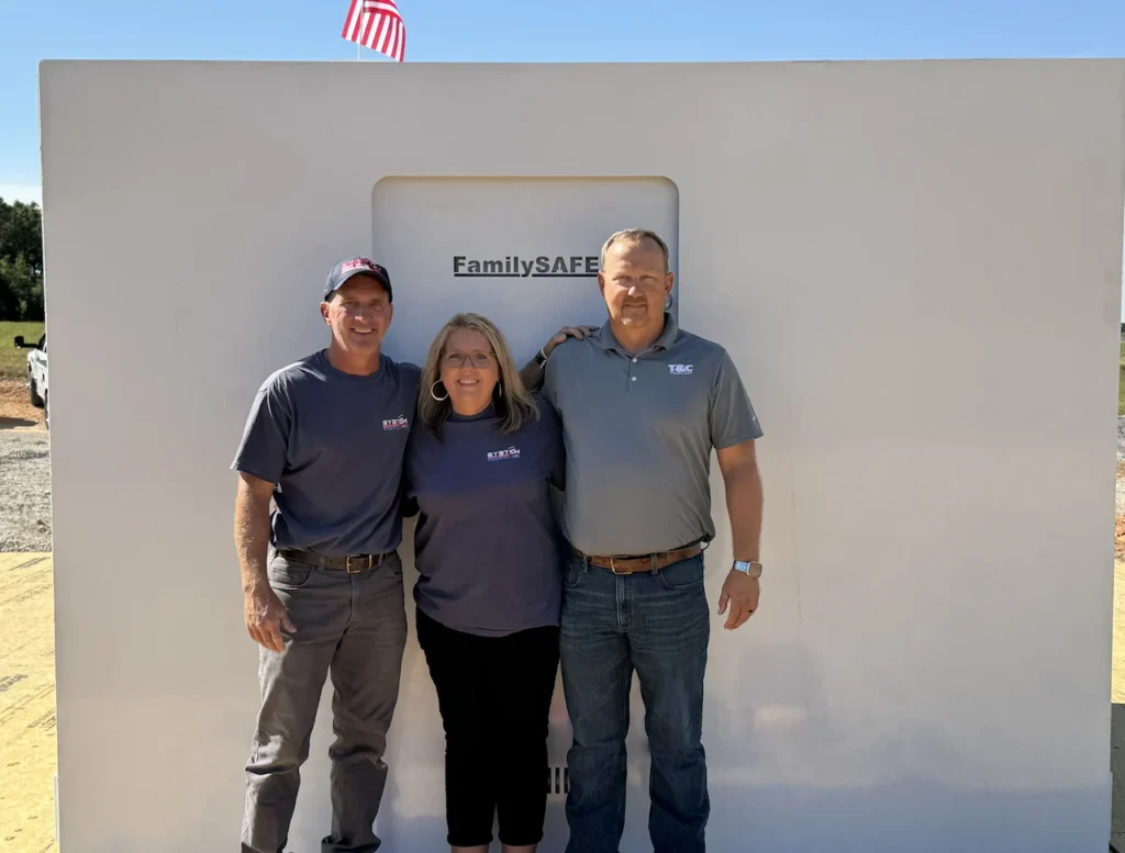 Three people standing in front of FamilySAFE shelter